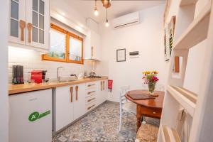 アムリアニにあるAmmou Areaの白いキャビネットと木製テーブル付きのキッチン