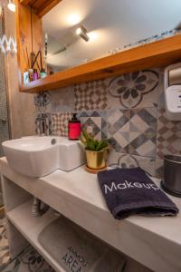 a bathroom with a white sink and a mirror at Ammou Area in Ammouliani