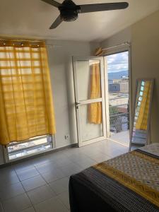 a bedroom with a bed and a large window at Central Appart in Mamoudzou