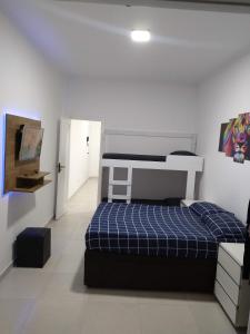 ein Schlafzimmer mit einem Bett mit einer blau karierten Matratze in der Unterkunft Apartamento Top Vista mar Boqueirao Gonzaga in Santos