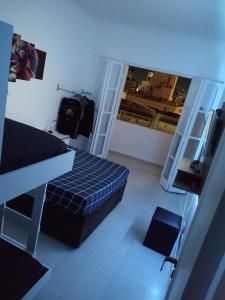 ein kleines Zimmer mit einem Bett und einem Spiegel in der Unterkunft Apartamento Top Vista mar Boqueirao Gonzaga in Santos