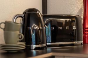 a black coffee maker and a cup on a counter at Die Alte Gerberei - La Vecchia Conceria OG2 in Monguelfo