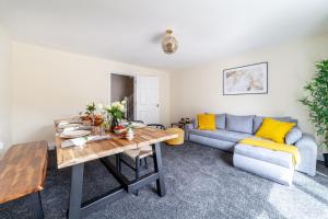 a living room with a table and a couch at Arte Stays- 3-Bedrooms 2-Bathrooms Garden Spacious House London, Stratford, Free Parking, 6 min walk Elizabeth Line, Weekly or Monthly stays, Serviced accommodation - 7 guests in London