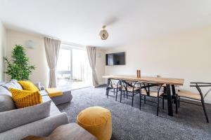 un soggiorno con divano e tavolo di Arte Stays- 3-Bedrooms 2-Bathrooms Garden Spacious House London, Stratford, Free Parking, 6 min walk Elizabeth Line, Weekly or Monthly stays, Serviced accommodation - 7 guests a Londra