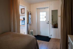 a bedroom with a bed and a door with a window at Lilla gröna huset på gården in Härnösand