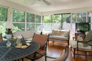 a living room with a table and chairs and windows at Pinecrest Bed & Breakfast in Asheville