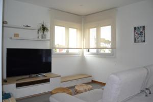 un soggiorno con TV a schermo piatto e 2 finestre di Casa Patricia a Pontevedra