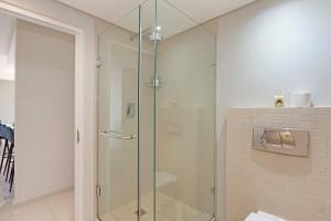 a shower with a glass door in a bathroom at Modern 3 Bed Apartment Blouberg in Cape Town +11 photos