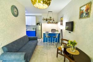 a living room with a blue couch and a kitchen at Perfect Place in Kutaisi