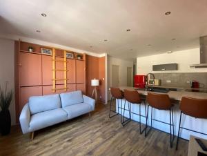 un soggiorno con un divano blu e una cucina di Appartement centre-ville, Valras-Plage, chez Géraud et Séverine a Valras-Plage