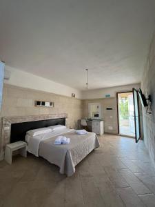 una camera con un grande letto e una cucina di Masseria Tumara Rooms and Apartments a Otranto