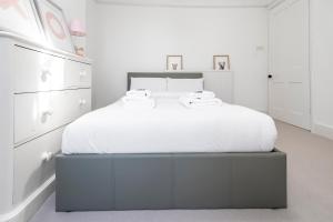 1 dormitorio blanco con 1 cama grande y muebles blancos en 4 BR Edwardian family house wgarden, Notting Hill, en Londres
