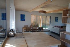 a living room with a wooden table and a couch at Maison bois Les Conches 6/8 Pers in Longeville-sur-Mer
