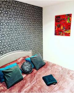 - une chambre avec un lit avec des oreillers et un mur dans l'établissement Chic 2 pièces, épuré & pragmatic à 5' de Paris, à Ivry-sur-Seine