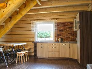 eine Küche in einem Blockhaus mit einem Tisch und einem Fenster in der Unterkunft A wooden eco friendly house by the Goszcza lake Living room 2 bedrooms in Lubrza