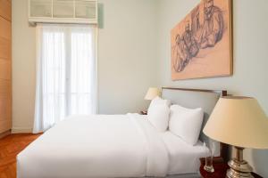 a bedroom with a white bed and a window at Brassbell l DT l Art Deco Designer Apartments in Cairo +20 photos
