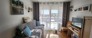 sala de estar con sofá y TV en Vue exceptionnelle sur la mer et le Cap Estérel en Saint-Raphaël