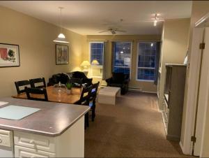 a kitchen and living room with a table and a couch at Mountain View Vacation Villa Main Floor Unit, No Stairs in Fairmont Hot Springs