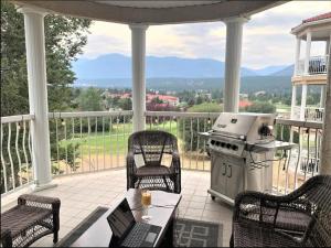 費爾蒙溫泉的住宿－Mountain View Vacation Villa Main Floor Unit, No Stairs，门廊设有烧烤架、桌子和椅子