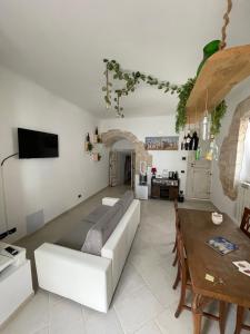 sala de estar con sofá blanco y mesa en B&B Antiche Mura en Sammichele di Bari