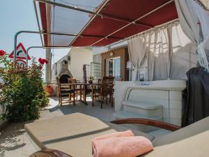 een patio met een tafel en stoelen en een open haard bij Luxurious Holiday Home in Arbanija with Jacuzzi in Trogir
