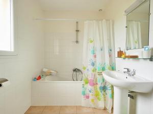 ein Badezimmer mit einem Waschbecken, einer Badewanne und einem Duschvorhang in der Unterkunft Villa with fire place in Loire region in Les Forges