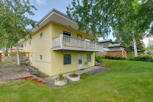 a yellow house with a balcony and a yard at Downtown Anchorage Vacation Rental with Garden Views in Anchorage