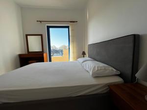 a bedroom with a large white bed with a window at Grammeno Seaside Studios in Palaiochora