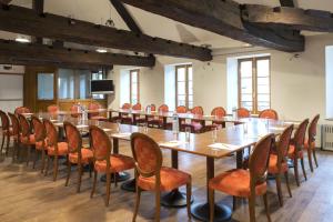 een grote vergaderzaal met een lange tafel en stoelen bij Le Saint Michel in Sedan