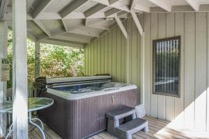 a hot tub on a patio with a table and a chair at Cedar Ridge in Oakland