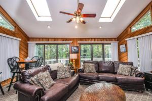 a living room with leather couches and a ceiling fan at Cedar Ridge in Oakland