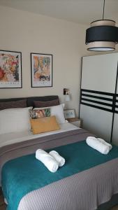 una camera da letto con un letto e due asciugamani di ElMar Homeliving a Volos