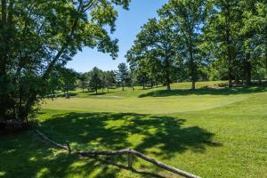 a view of a golf course with trees and grass at Sunkissed Lodge in McHenry