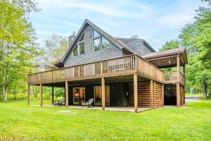 a large house with a deck on a lawn at Woodhaven in Swanton