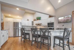 a kitchen with white cabinets and bar stools at Johnny Appleseed in Oakland +76 photos