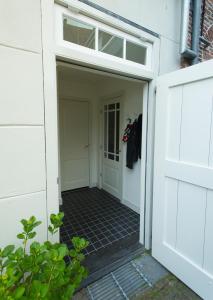 une porte ouverte menant à un garage avec la porte ouverte dans l'établissement Waterland Achterhuis, à Monnickendam