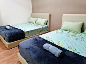 a bedroom with two beds and a pillow on the floor at Home in Bayan Lepas4R3B Dnaz Homestay@Bayan Baru in Bayan Lepas
