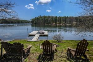 two chairs and a dock on a lake at Ski Shore in Swanton