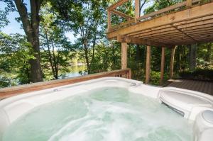 a jacuzzi tub on a deck with a wooden roof at Ski Shore in Swanton