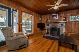 a living room with a fireplace and a chair at Ski Shore in Swanton