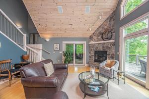 a living room with leather furniture and a stone wall at Play-A-Way Chalet in McHenry