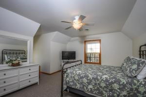 a bedroom with a bed and a ceiling fan at Sparkys Lodge in McHenry