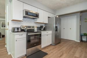a kitchen with white cabinets and stainless steel appliances at Waltzing Matilda in Swanton
