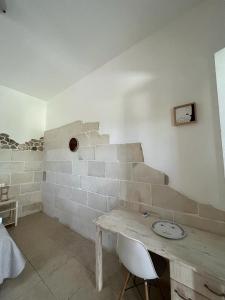una camera con un muro in pietra, tavolo e sedie di Masseria Tumara Rooms and Apartments a Otranto