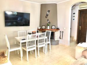 comedor con mesa, sillas y TV en La Casa de Jordi&Lina, en Miami Platja