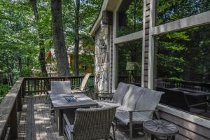 a patio with chairs and a table on a deck at Slip Away Chalet in McHenry