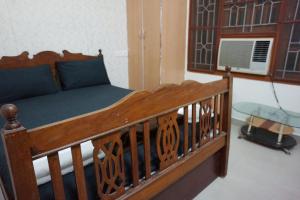 1 dormitorio con cama de madera con sábanas azules en VPR Cottage, en Yelagiri