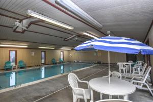 - une piscine avec une table et un parasol dans l'établissement Sunset Chalet 706, à McHenry