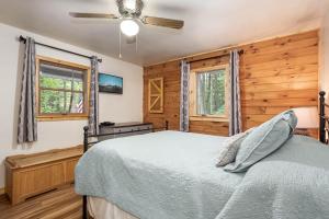 een slaapkamer met een bed en een plafondventilator bij Lincoln Log Cabin in Oakland