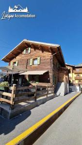 een houten gebouw met een bank ervoor bij Appartamenti Barin by Livigno Accomodation in Livigno